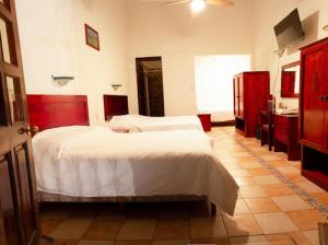 瓦哈卡市Hotel Nueva Antequera的一间带两张床的卧室和一间带水槽的浴室