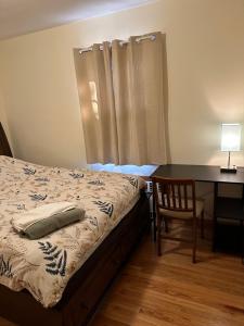 新不伦瑞克M1 Queen Size BedRoom with desk near Rutgers U & hospitals的一间卧室配有一张床、一张桌子和一张桌子