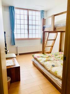 小樽Otaru Garden Stay的一间卧室设有两张双层床和一扇窗户。