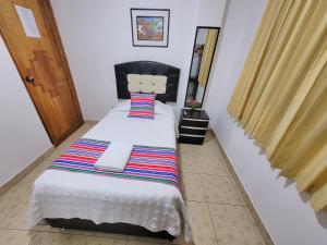奥兰太坦波Hostal EL VIAJERO en Ollantaytambo的小卧室配有带条纹毯子的床