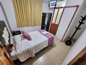奥兰太坦波Hostal EL VIAJERO en Ollantaytambo的一间卧室配有一张床和一台电视