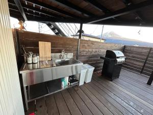 富士河口湖Glamping Dome YOSHIMURA的甲板上的厨房设有水槽和烧烤架