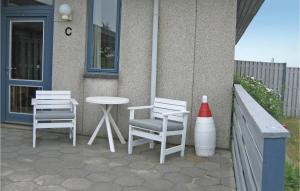 哈夫維格Pet Friendly Apartment In Hvide Sande With Wifi的庭院里设有两把椅子和一张桌子