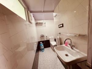 奈尼塔尔The Cocoon Camps & nature Resorts的白色的浴室设有水槽和卫生间。