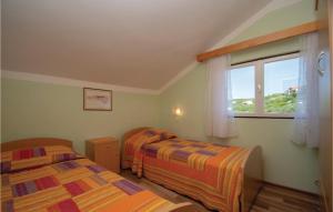 尼亚卢卡Beautiful Home In Tankaraca With Outdoor Swimming Pool的一间卧室设有两张床和窗户。