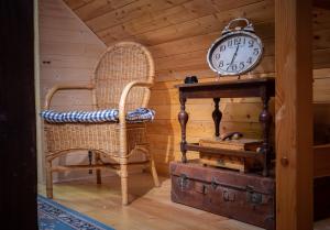 LibošoviceChaloupka pod skalou的一间带椅子、时钟和行李的房间