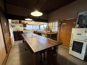 岬町犬と泊まれる平屋Dog friendly house 黄昏的厨房配有大木桌和冰箱。