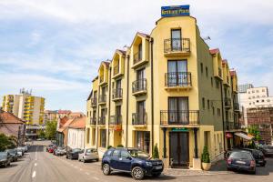 札勒乌辉煌广场酒店的停在黄色建筑前面的蓝色汽车