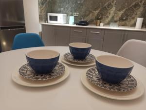 阿斯塔纳1-ком.квартира от ИП Дома света, перекресток Кенесары-Кумисбекова的桌子上两个蓝色的杯子和碟子