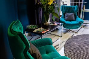 札勒乌辉煌广场酒店的客厅配有绿色椅子和桌子