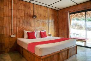 高兰Chom Dao Resort的一间卧室配有一张带红色枕头的大床