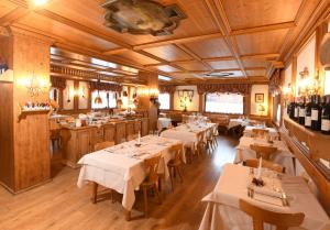 瓦尔迪佐多Hotel Valgranda Wellness & Spa的一间餐厅,房间内设有白色的桌椅