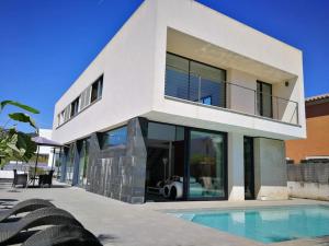 马略卡岛帕尔马Precioso chalet vanguardista的一座白色的房子,前面设有一个游泳池
