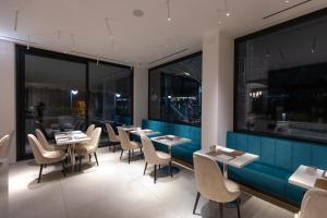 耶西德纳尼酒店的餐厅设有桌椅和大窗户。