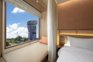 乌汶Centara Ubon的一间卧室设有一张床和一个美景窗户。