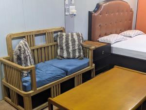新德里HOTEL THE CUBE STAY的一间设有婴儿床、床和桌子的房间