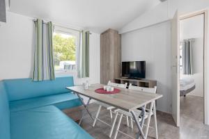 博里霍尔姆First Camp Ekerum - Öland的客厅配有桌子和蓝色沙发
