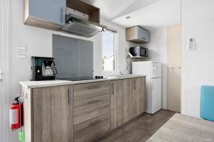博里霍尔姆First Camp Ekerum - Öland的厨房配有木制橱柜和白色冰箱。