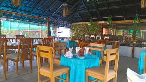 库亚加塔Banorupa Kuakata hotel的一间设有蓝色桌椅的餐厅和一间酒吧