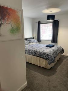 格洛斯特Large 2 bedroom apartment, 4 beds one 1 en-suite, Free parking Nr Chelt Elmore and Quays的卧室配有一张床,墙上挂有绘画作品