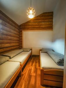 Súľov-HradnáKoliba Pod Skalami的配有2张床的带木地板和吊灯的客房