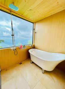 竹山深山林内民宿 的带浴缸的浴室和大窗户