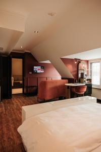 赖斯韦克Hotel & Spa Savarin - Rijswijk, The Hague的一间卧室配有一张床铺和一张桌子,还设有一间厨房