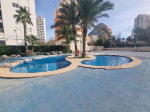 卡尔佩Pisito Rico的三个棕榈树泳池和建筑