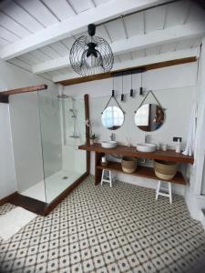 洛斯雷亚莱霍斯Casa La Aldaba的一间带两个水槽和玻璃淋浴间的浴室