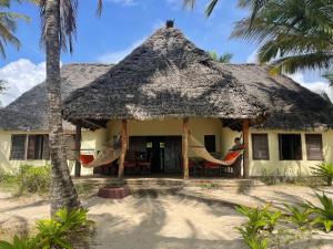 Ushongo MabaoniEmbedodo Beach House, Ushongo beach, Pangani的房屋设有吊床和茅草屋顶