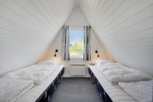 勒兹比Lalandia Rødby的带窗户的客房内的三张床