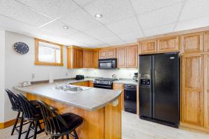 JayJay Peak Village Home 367B的厨房配有木制橱柜和黑色冰箱。