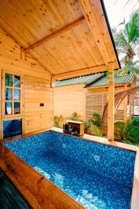 阿贡达orange sky beach bungalow的一个带木制凉亭的室外游泳池