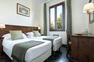 罗马Grand Hotel Gianicolo的酒店客房设有两张床和窗户。