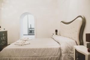 马泰拉Acasadifelice的白色卧室,配有带毛巾的床