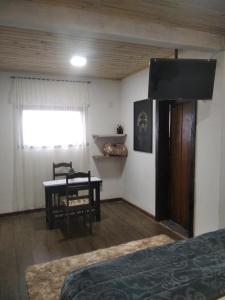 拉夫拉斯诺瓦斯Chalé Suite do chá的一间卧室配有一张床、一张桌子和一个窗户。