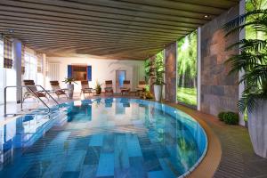 维林根WILLINO Privathotel的蓝色瓷砖房子内的游泳池