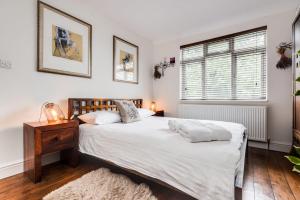 牛津Orchard - 3 Bedroom House Headington & parking & garden的一间卧室设有两张床、一张桌子和一个窗口