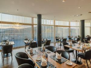 施泰格斯巴赫Falkensteiner Balance Resort Stegersbach - Adults only的餐厅设有桌椅和大窗户。