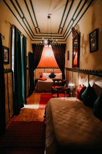 马拉喀什Riad Hotel Sherazade的酒店客房设有两张床和一张桌子。