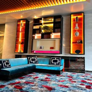 吉隆坡THE FACE Style的客厅配有蓝色的沙发和地毯。