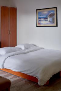 拉法洛维奇Orange的一张大白色的床,墙上挂着一张照片