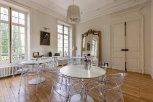 里摩日La Villa Beaupeyrat - Apparthôtels de charme dans bâtisse de caractère的用餐室配有椅子、桌子和镜子