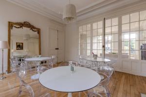 里摩日La Villa Beaupeyrat - Apparthôtels de charme dans bâtisse de caractère的配有桌椅和镜子的房间