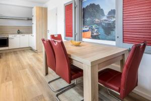 辛根Ferienwohnung Katzmaier的厨房以及带木桌和红色椅子的用餐室。