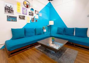 孟买Locomo Mumbai - Stay Work Eat的客厅配有蓝色的沙发和桌子