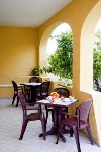 卡拉古诺内Affittacamere Casa del Sole的餐厅设有桌椅和2扇窗户。