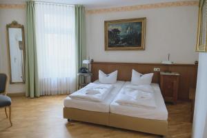 莱比锡勒佩兹家尔航德酒店的一间卧室配有带白色枕头的床