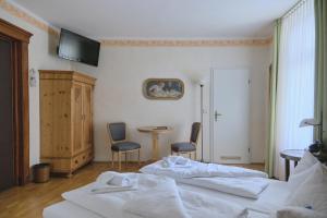 莱比锡勒佩兹家尔航德酒店的一间卧室配有两张床和一张桌子及椅子