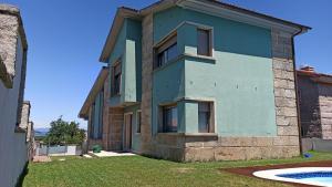 桑亨霍Casa Rouxique的蓝色的房子,前面有一个游泳池